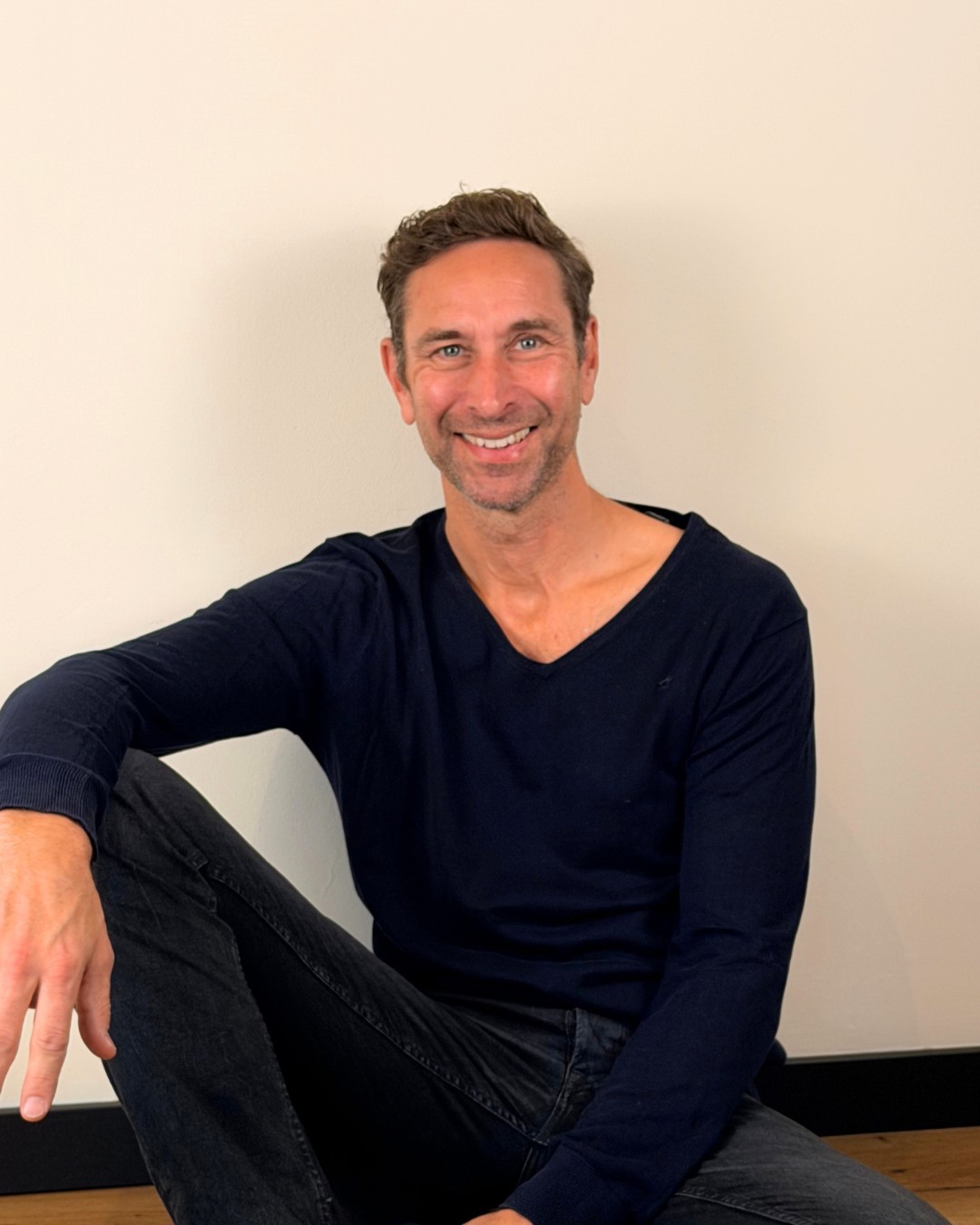 Guido Brock sitzt entspannt auf dem Boden des SATYA 91 in Köln-Lövenich